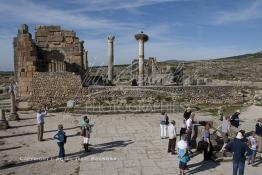 Image du Maroc Professionnelle de  Les touristes se rassemblent autour des arches de la basilique, le principal bâtiment administratif de Volubilis.
Le site de Volubilis est l'un des sites les mieux préservés au Maroc et le plus visité. La cité romaine se situe à proximité de Moulay Idriss Zerhoun à une trentaine de km au nord-ouest de Meknès, photo prise le jeudi 8 Mars 2012. Volubilis ville antique berbère Walili (Lauriers rose) qui date du 3e siècle avant J.-C. capitale du royaume de Maurétanie fondé comme seconde capital sous le règne de Juba II. (Photo / Abdeljalil Bounhar)
 